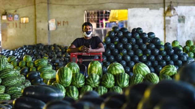 A vendor waits for customers at APMC market during a nationwide strike, in Mumbai on December 8. The Colaba weather station, representative of south Mumbai region, recorded a maximum temperature of 35.4 degrees Celsius for the day, three degrees Celsius above normal. (Shashank Parade / PTI)