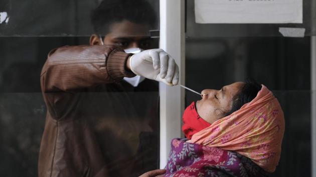 A health worker collects a swab sample from a woman for Covid-19 test, at Sector 30 District Hospital, in Noida on Tuesday. (Sunil Ghosh/HT Photo) A health worker collects a swab sample from a woman for Covid-19 test, at Sector 30 District Hospital, in Noida on Tuesday. (Sunil Ghosh/HT Photo)