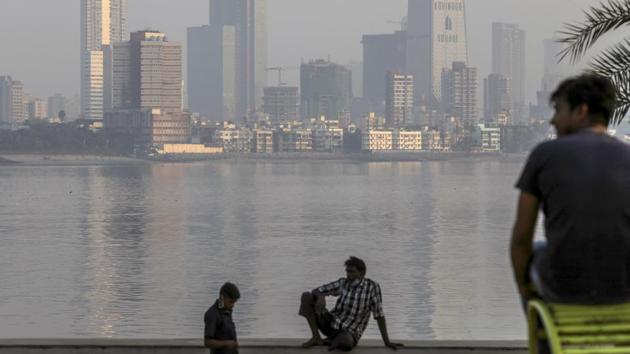 People seated by the waterfront in Parel, Mumbai on December 4. Moisture levels for December 8 were low, with 71% and 62% humidity in the suburbs and south Mumbai, respectively. The minimum temperature in the suburbs, meanwhile, was 18.2 degrees Celsius and 22.2 degrees Celsius in the suburbs and south Mumbai, both close to the normal mark. (Dhiraj Singh / Bloomberg)