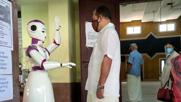 The robot named Sayabot greets a voter at a polling station in Kerala’s Ernakulam .(HT PHOTO)