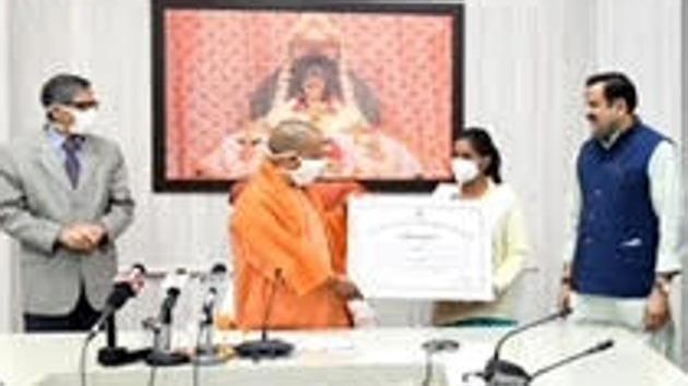 UP chief minister Yogi Adityanath gives a giant replica of appointment letter to a newly appointed woman tube well operator in Lucknow on Wednesday. (Sourced Photo) UP chief minister Yogi Adityanath gives a giant replica of appointment letter to a newly appointed woman tube well operator in Lucknow on Wednesday. (Sourced Photo)