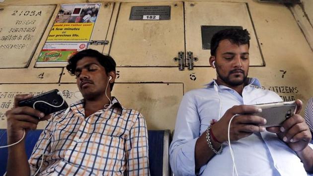 Commuters watch videos on their mobile phones as they travel in a suburban train in Mumbai. (REUTERS) Commuters watch videos on their mobile phones as they travel in a suburban train in Mumbai. (REUTERS)