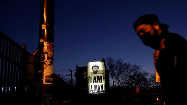 A man wearing a protective face mask walks past a billboard as the outbreak of the coronavirus disease (Covid-19) continues, in Chicago, Illinois, US. (Reuters) A man wearing a protective face mask walks past a billboard as the outbreak of the coronavirus disease (Covid-19) continues, in Chicago, Illinois, US. (Reuters)
