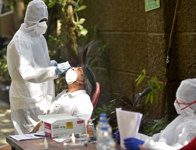A health worker takes a swab sample of a resident in Goregaon on Wednesday.(Satyabrata Tripathy/HT Photo) A health worker takes a swab sample of a resident in Goregaon on Wednesday.(Satyabrata Tripathy/HT Photo)