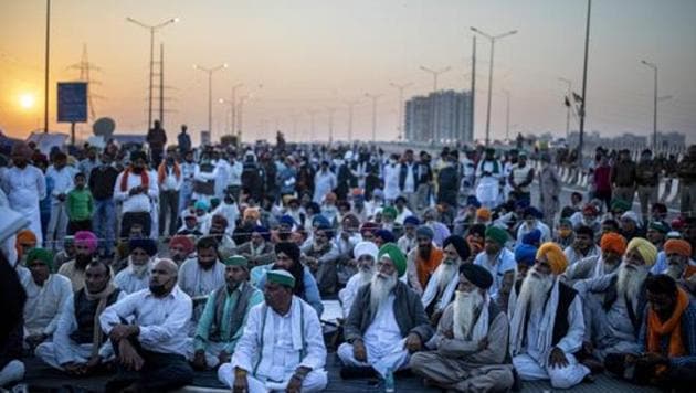 Farmers listen to a speaker on the middle of an expressway at the site of a protest against new farm laws at the Delhi-Uttar Pradesh state border.(AP) Farmers listen to a speaker on the middle of an expressway at the site of a protest against new farm laws at the Delhi-Uttar Pradesh state border.(AP)