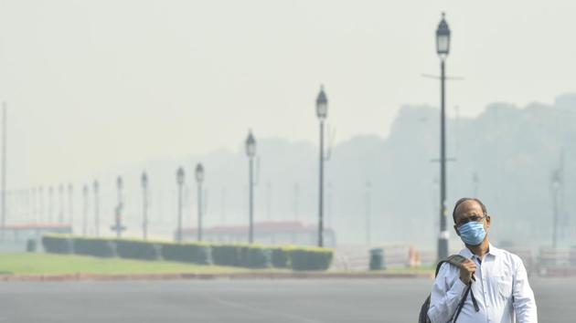 A man wearing a face mask walks on Rajpath amid hazy weather conditions, in New Delhi. (File photo) A man wearing a face mask walks on Rajpath amid hazy weather conditions, in New Delhi. (File photo)