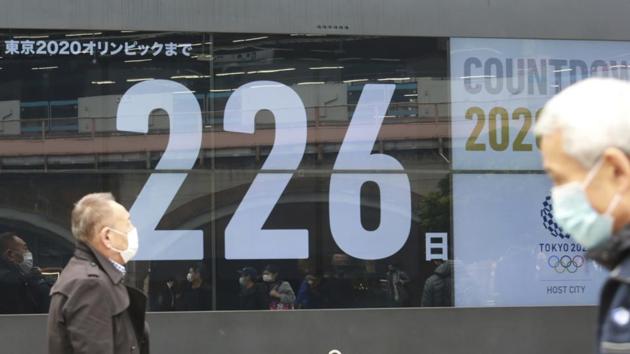 People wearing face masks to protect against the coronavirus walk in front of an Olympic countdown clock in Tokyo, Wednesday, Dec.9, 2020. Domestic sponsors have already contributed a record of $3.3 billion to help pay for the Tokyo Olympics. That's at least twice as much as any previous Games. It's still not enough. Now they're being asked to pay millions more to cover some of the soaring costs of the one-year postponement. (AP Photo/Koji Sasahara) (AP) People wearing face masks to protect against the coronavirus walk in front of an Olympic countdown clock in Tokyo, Wednesday, Dec.9, 2020. Domestic sponsors have already contributed a record of $3.3 billion to help pay for the Tokyo Olympics. That's at least twice as much as any previous Games. It's still not enough. Now they're being asked to pay millions more to cover some of the soaring costs of the one-year postponement. (AP Photo/Koji Sasahara) (AP)