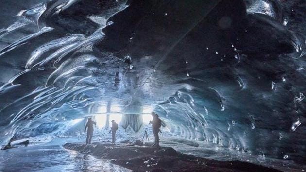 People stand in the "Mill", a 20m long natural ice cave created by melted water accumulated during the summer and by a siphon effect leaves in the autumn giving way to an ice cathedral, at the Glacier 3000 ski resort in Les Diablerets, Switzerland.(REUTERS)