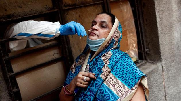 A medical worker collects a sample from a woman at a school which was turned into a centre to conduct tests for COVID-19, during the coronavirus disease (COVID-19) outbreak, in New Delhi. (REUTERS) A medical worker collects a sample from a woman at a school which was turned into a centre to conduct tests for COVID-19, during the coronavirus disease (COVID-19) outbreak, in New Delhi. (REUTERS)