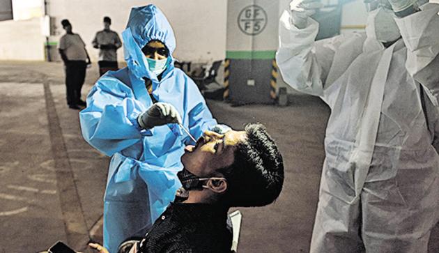 A healthcare worker collects swab sample from a resident in Dadar. (Satish Bate/HT Photo) A healthcare worker collects swab sample from a resident in Dadar. (Satish Bate/HT Photo)