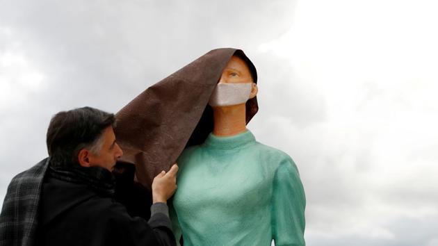 Father Enzo Fortunato uncovers a life size figurine of a nurse outside the Basilica of St. Francis of Assisi, in honour of medical workers who have been battling the coronavirus disease (Covid-19) this year, in Assisi, Italy on December 7. (Yara Nardi / REUTERS) Father Enzo Fortunato uncovers a life size figurine of a nurse outside the Basilica of St. Francis of Assisi, in honour of medical workers who have been battling the coronavirus disease (Covid-19) this year, in Assisi, Italy on December 7. (Yara Nardi / REUTERS)