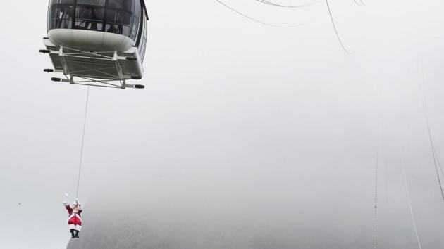 A man dressed as Santa Claus rappels from a cable car while descending from the Pao de Acucar Mountain (Sugar Loaf Mountain) during his arrival to a Christmas event in Rio de Janeiro, Brazil on December 5. (Ricardo Moraes / REUTERS) A man dressed as Santa Claus rappels from a cable car while descending from the Pao de Acucar Mountain (Sugar Loaf Mountain) during his arrival to a Christmas event in Rio de Janeiro, Brazil on December 5. (Ricardo Moraes / REUTERS)