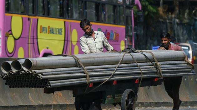 Worker push a hand-cart loaded with metal pipes in Mumbai. (AFP) Worker push a hand-cart loaded with metal pipes in Mumbai. (AFP)