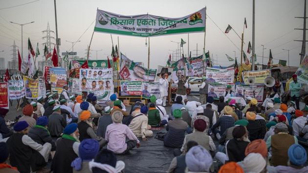 Farmers listen to a speaker, sitting in the middle of an expressway at the site of a protest against new farm laws at the Delhi-Uttar Pradesh state border. (AP) Farmers listen to a speaker, sitting in the middle of an expressway at the site of a protest against new farm laws at the Delhi-Uttar Pradesh state border. (AP)