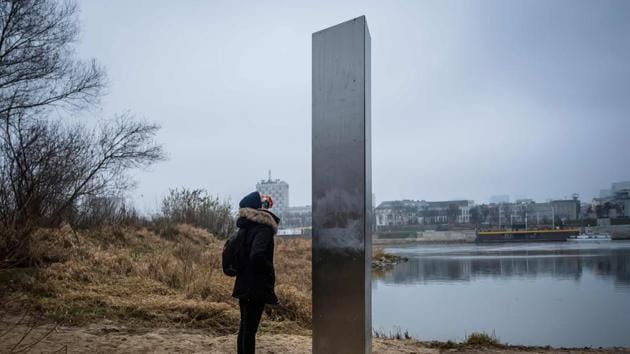 A woman looks at a metal monolith that has popped up on a riverbank of the Vistula in the Polish capital Warsaw, the latest in a string of similar objects that have recently appeared in Europe and the US, on December 10. Similar looking objects have been found over recent weeks in the United States, Romania and Britain. (Wojtek Radwanski / AFP) A woman looks at a metal monolith that has popped up on a riverbank of the Vistula in the Polish capital Warsaw, the latest in a string of similar objects that have recently appeared in Europe and the US, on December 10. Similar looking objects have been found over recent weeks in the United States, Romania and Britain. (Wojtek Radwanski / AFP)