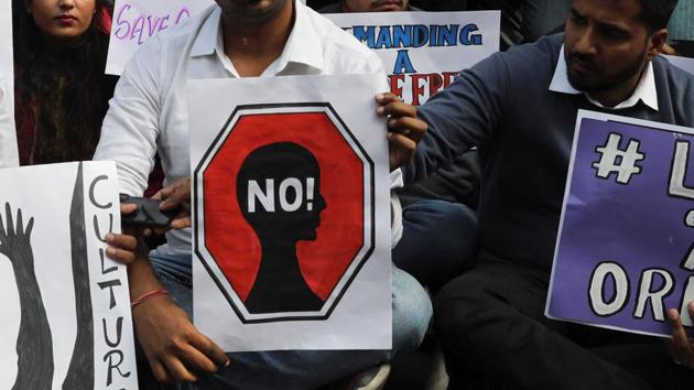 People hold placards and shout slogans as they protest against the alleged rape and murder of a woman.(REUTERS)