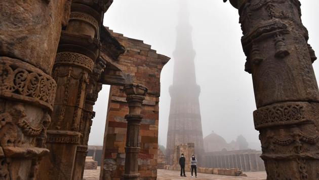 Visitors stroll in the Qutub Minar complex, in New Delhi on December 13. Most cities and towns in northwest India recorded moderate to poor category air on December 14 morning. Delhi recorded an air quality index of 160 in the moderate category. (Sanchit Khanna / HT Photo) 