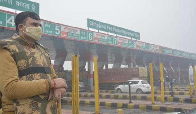 A policeman at Chajjarsi toll plaza, where farmers are camped in protest against three new farm laws, in Hapur district of Uttar Pradesh on Saturday.(Sakib Ali/HT Photo)