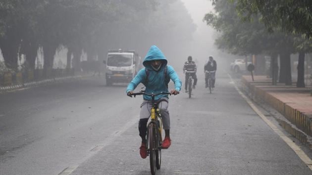 Cyclists out in amid morning fog on Sector 31 road, in Noida on Saturday, December 12, 2020. (Photo by Sunil Ghosh/ Hindustan Times)