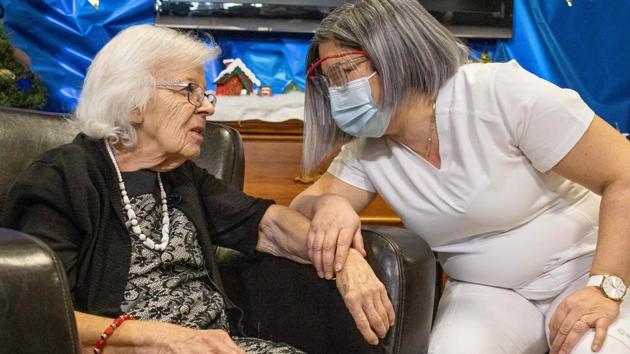 A handout picture released by the Ministère de la Santé et des Services sociaux (MSSS) of Quebec on December 14, 2020 shows Saint-Antoine long-term care home resident Gisele Levesque (left) getting ready to be vaccinated against Covid-19 in Quebec City, Canada.(AFP)