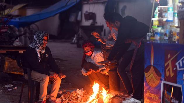 People warm themselves next to a bonfire on a cold winter evening, at Minto Road, in New Delhi on Monday. (Raj K Raj/HT PHOTO) People warm themselves next to a bonfire on a cold winter evening, at Minto Road, in New Delhi on Monday. (Raj K Raj/HT PHOTO)