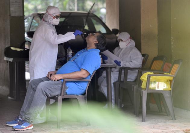A health worker takes a swab sample of a resident in Malad on Monday. (Satyabrata Tripathy/HT Photo) A health worker takes a swab sample of a resident in Malad on Monday. (Satyabrata Tripathy/HT Photo)