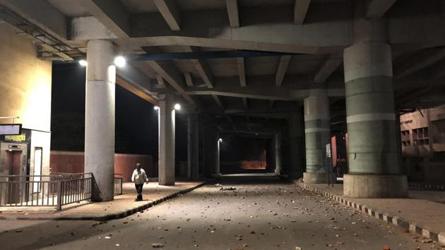 A person walks past a street strewn with bricks and pebbles outside Jamia Millia Islamia on December 15. Dozens were injured in the clashes over four hours in the area surrounding Jamia Millia Islamia on Sunday, police said. A witness said protesters and police could be seen hurling stones at each. Agitators also vandalised property at some places, he said. (Saaliq Sheikh / AP)