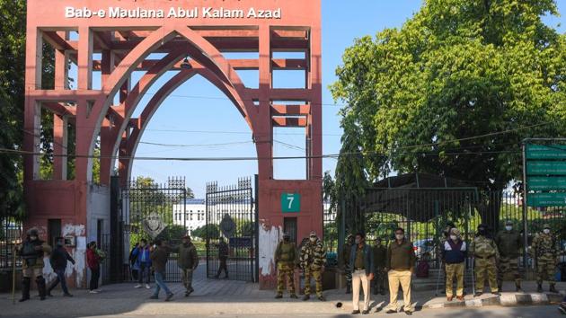 Security personnel outside Jamia Millia Islamia on December 14, almost a year after the violence. Following the events of December 15, the university strengthened security, repaired the damaged libraries. During the three-month long protest, the boundary walls of the campus had been painted with protest graffiti, murals and art installations celebrating resistance, unity and brotherhood which have now been removed. (Amal KS / HT Photo)