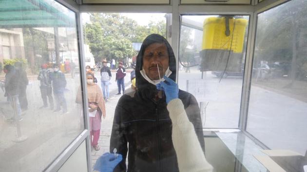 Noida, India - December 15, 2020: A health worker collects a swab sample from a man for coronavirus testing, at Sector 30 District Hospital, in Noida, India, on Tuesday, December 15, 2020.(Sunil Ghosh / Hindustan Times)