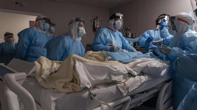 Medical professionals perform tracheostomy procedure on a patient inside the Covid-19 intensive care unit (ICU) at the United Memorial Medical Center in Houston on December 14. The number of coronavirus deaths in the United States crossed 300,000 on December 14 as the hardest hit Covid-19 nation rolled out its first vaccine inoculations, Reuters reported. (Go Nakamura / Getty Images / AFP )