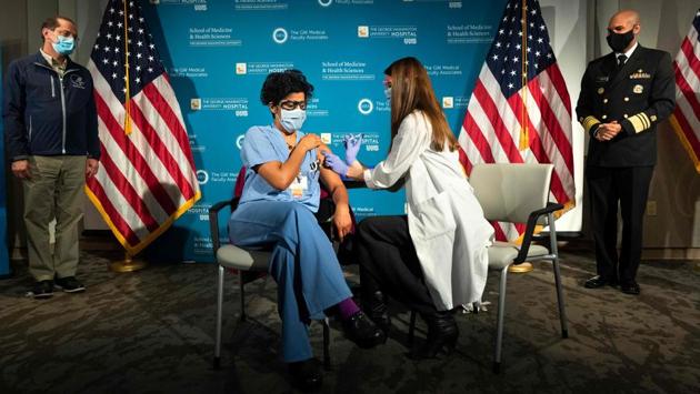 Dr Sheetal Sheth, OB-GYN and Medical Director for Labor and Delivery at George Washington University Hospital, is vaccinated for Covid-19 by nurse Lillian Wirpsza, in Washington on December 14. The staggering death toll came as US began a historic inoculation campaign using a vaccine developed by Pfizer Inc and BioNTech SE. Moderna Inc’s vaccine could get approval as soon as this week, Reuters reported. (Jacquelyn Martin / AFP) Dr Sheetal Sheth, OB-GYN and Medical Director for Labor and Delivery at George Washington University Hospital, is vaccinated for Covid-19 by nurse Lillian Wirpsza, in Washington on December 14. The staggering death toll came as US began a historic inoculation campaign using a vaccine developed by Pfizer Inc and BioNTech SE. Moderna Inc’s vaccine could get approval as soon as this week, Reuters reported. (Jacquelyn Martin / AFP)