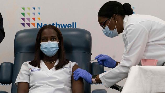 Sandra Lindsay (L), a nurse, is inoculated with the Covid-19 vaccine by Dr. Michelle Chester at Long Island Jewish Medical Center, on December 14, in New York. The rollout of the Pfizer-BioNTech vaccine, the first to be approved by the Unites States Food and Drug Administration (FDA), ushered in the biggest vaccination effort in US history on December 14. (Mark Lennihan / Pool / AFP)