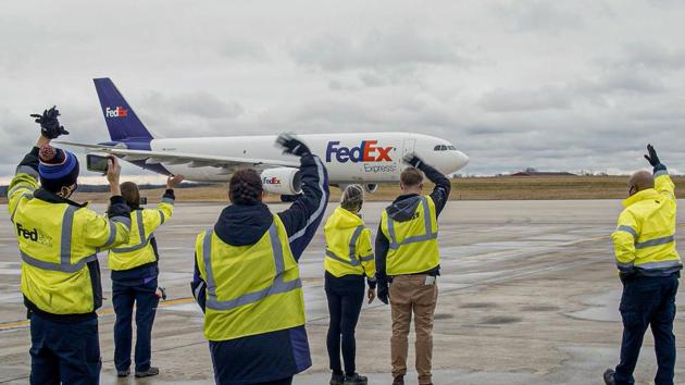 FedEx employees wave as a plane filled with Covid-19 vaccines departs from an undisclosed city to various destinations on December 14. Some 145 sites around the United States, from Rhode Island to Alaska, have received shipments, with more deliveries set for the coming days. High-risk health care workers and nursing home residents are first in line for inoculation. (FedEX / AFP) FedEx employees wave as a plane filled with Covid-19 vaccines departs from an undisclosed city to various destinations on December 14. Some 145 sites around the United States, from Rhode Island to Alaska, have received shipments, with more deliveries set for the coming days. High-risk health care workers and nursing home residents are first in line for inoculation. (FedEX / AFP)