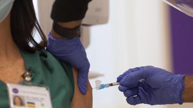 Nurse Frank Baez administers the Covid-19 vaccine to Tara Easter, a nurse manager of the hospital's medical ICU, at NYU-Langone Hospital on Monday. (AP Photo) Nurse Frank Baez administers the Covid-19 vaccine to Tara Easter, a nurse manager of the hospital's medical ICU, at NYU-Langone Hospital on Monday. (AP Photo)