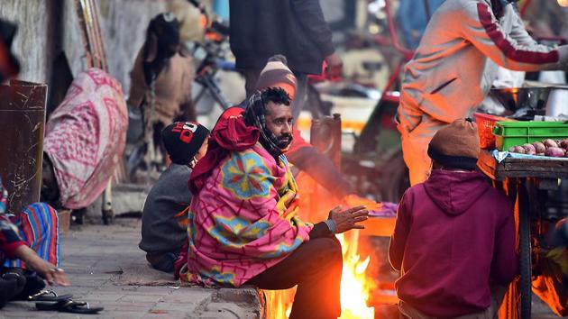 People warm themselves next to a bonfire on a cold winter evening, at Minto Road, in New Delhi on Monday. (Raj K Raj/HT Photo) People warm themselves next to a bonfire on a cold winter evening, at Minto Road, in New Delhi on Monday. (Raj K Raj/HT Photo)