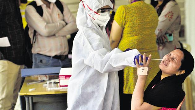 Healthcare workers collect swab samples of a resident in Goregaon, on Tuesday. (Satyabrata Tripathy/HT Photo) Healthcare workers collect swab samples of a resident in Goregaon, on Tuesday. (Satyabrata Tripathy/HT Photo)