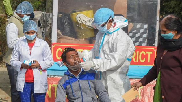 A healthcare worker, wearing protective gear, collects swab sample for Covid-19 test, in New Delhi on Tuesday.(PTI Photo) A healthcare worker, wearing protective gear, collects swab sample for Covid-19 test, in New Delhi on Tuesday.(PTI Photo)