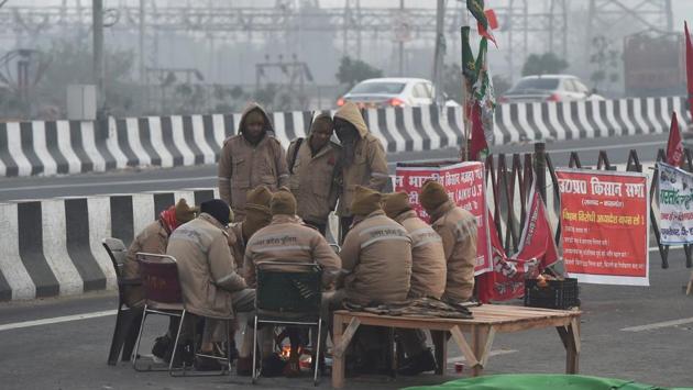 Security personnel warm themselves around a bonfire during farmers’ sit-in protest at Ghazipur border near New Delhi on December 16. On December 15, the maximum temperature recorded was 18.5 degrees Celsius at Safdarjung, 5 degrees Celsius below normal and 16.7 degrees Celsius at Palam, 7 degrees Celsius below normal, HT reported. (Manvender Vashist / PTI) Security personnel warm themselves around a bonfire during farmers’ sit-in protest at Ghazipur border near New Delhi on December 16. On December 15, the maximum temperature recorded was 18.5 degrees Celsius at Safdarjung, 5 degrees Celsius below normal and 16.7 degrees Celsius at Palam, 7 degrees Celsius below normal, HT reported. (Manvender Vashist / PTI)