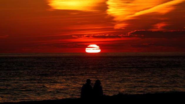 A couple watches the sun sets over the Atlantic Ocean at Cape May Point in New Jersey on December 13. According to Reuters analysis, the United States is reporting 91 deaths per 100,000 people, seventh worst in the world on a per capita basis. (Mike Segar / REUTERS) A couple watches the sun sets over the Atlantic Ocean at Cape May Point in New Jersey on December 13. According to Reuters analysis, the United States is reporting 91 deaths per 100,000 people, seventh worst in the world on a per capita basis. (Mike Segar / REUTERS)