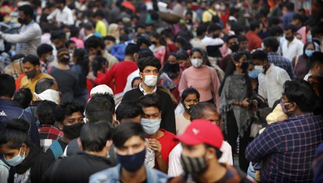 Indians wearing face masks as a precaution against the coronavirus shop at a market in New Delhi, India.(AP)