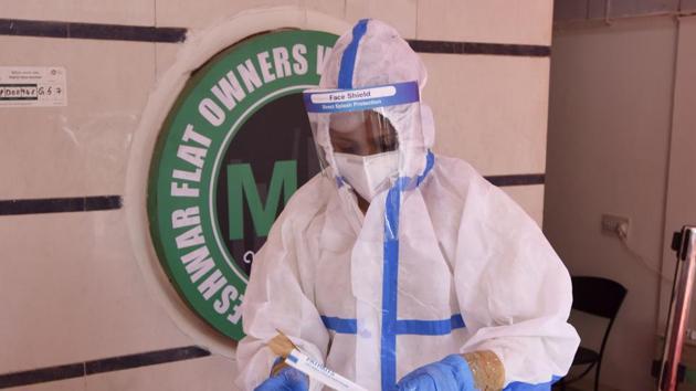 A health worker preserves a swab sample for coronavirus test, at Connaught Place, in New Delhi, India, on Wednesday, December 16, 2020. A free Covid testing camp organised by NDTA & SDA is set up at Connaught Place. (Photo by Sanjeev Verma/ Hindustan Times)