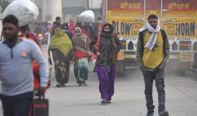 Commuters wear face masks and winter clothes on a cold morning at Azadpur in New Delhi on Tuesday.(Sanchit Khanna /HT PHOTO) Commuters wear face masks and winter clothes on a cold morning at Azadpur in New Delhi on Tuesday.(Sanchit Khanna /HT PHOTO)