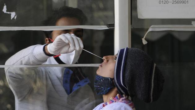 A health worker collects a swab sample from a woman for Covid-19 test, at Sector 30 District Hospital, in Noida. (Sunil Ghosh/HT Photo) A health worker collects a swab sample from a woman for Covid-19 test, at Sector 30 District Hospital, in Noida. (Sunil Ghosh/HT Photo)