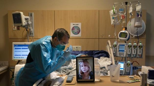 Chaplain Kevin Deegan prays for Covid-19 patient Pedro Basulto while on a video call with the patient's daughter, Grace, at Providence Holy Cross Medical Center in the Mission Hills section of Los Angeles. (AP) Chaplain Kevin Deegan prays for Covid-19 patient Pedro Basulto while on a video call with the patient's daughter, Grace, at Providence Holy Cross Medical Center in the Mission Hills section of Los Angeles. (AP)