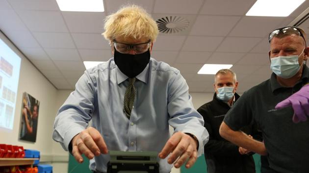 Britain's Prime Minister Boris Johnson tries his hand at cable splicing during a visit to the Openreach Learning and Development Training Centre in Bolton, Greater Manchester, northwest England, on December 18, 2020.(AFP) Britain's Prime Minister Boris Johnson tries his hand at cable splicing during a visit to the Openreach Learning and Development Training Centre in Bolton, Greater Manchester, northwest England, on December 18, 2020.(AFP)