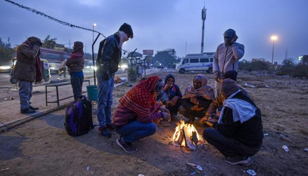People warm themselves around a bonfire on a cold winter morning at Sarai Kale Khan, in New Delhi on December 17. (Biplov Bhuyan/HT photo) People warm themselves around a bonfire on a cold winter morning at Sarai Kale Khan, in New Delhi on December 17. (Biplov Bhuyan/HT photo)