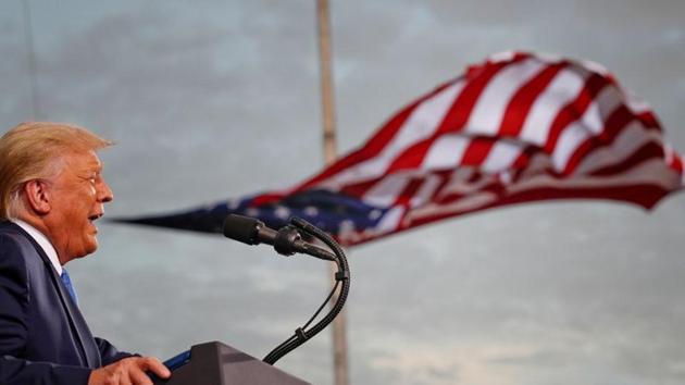 President Donald Trump speaks, with a flag behind him, during a campaign rally at Cecil Airport in Jacksonville, Florida, US.(REUTERS)