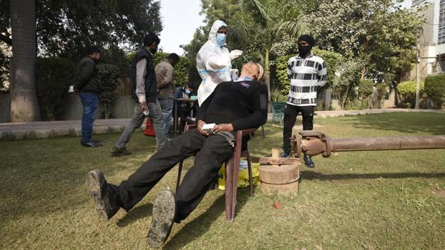 A health worker collects a swab sample for coronavirus testing in Gurugram on December 15. With 22,890 new cases of the coronavirus disease (Covid-19) and 338 fatalities in the last 24 hours, India’s infection tally has gone up to 9,979,447, according to the Union health ministry’s data on December 18. (PArveen Kumar / HT Photo)