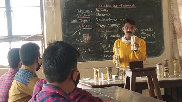 A teacher demonstrates a science experiment in a classroom, which was also streamed live to other students attending online classes, at Tilak High School in Karad, Satara. A teacher demonstrates a science experiment in a classroom, which was also streamed live to other students attending online classes, at Tilak High School in Karad, Satara.