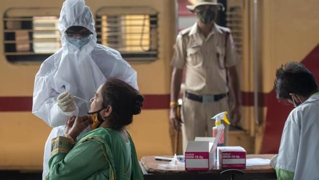 A health care worker collects swab sample of the passengers at Dadar station in Mumbai on Friday.(Pratik Chorge/HT Photo) A health care worker collects swab sample of the passengers at Dadar station in Mumbai on Friday.(Pratik Chorge/HT Photo)